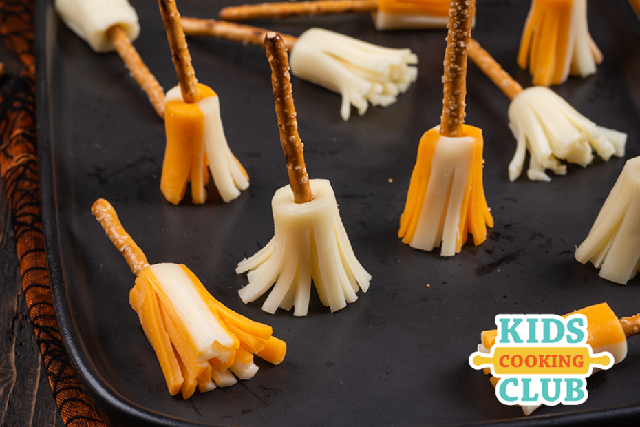 witches broom made with a pretzel and a piece of cheese string. Logo: Kids Cooking Club