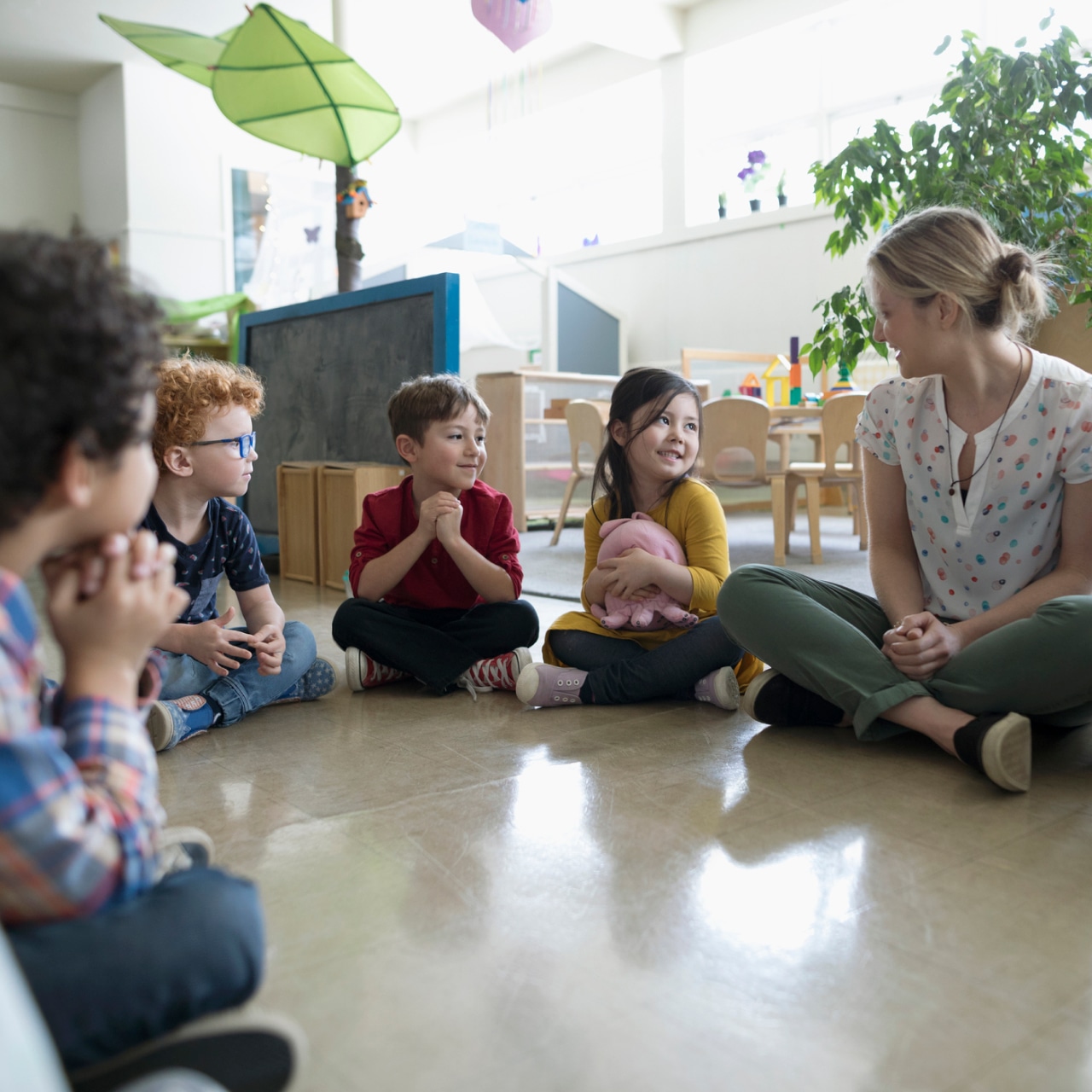 Teacher setting with kids in a preschool class