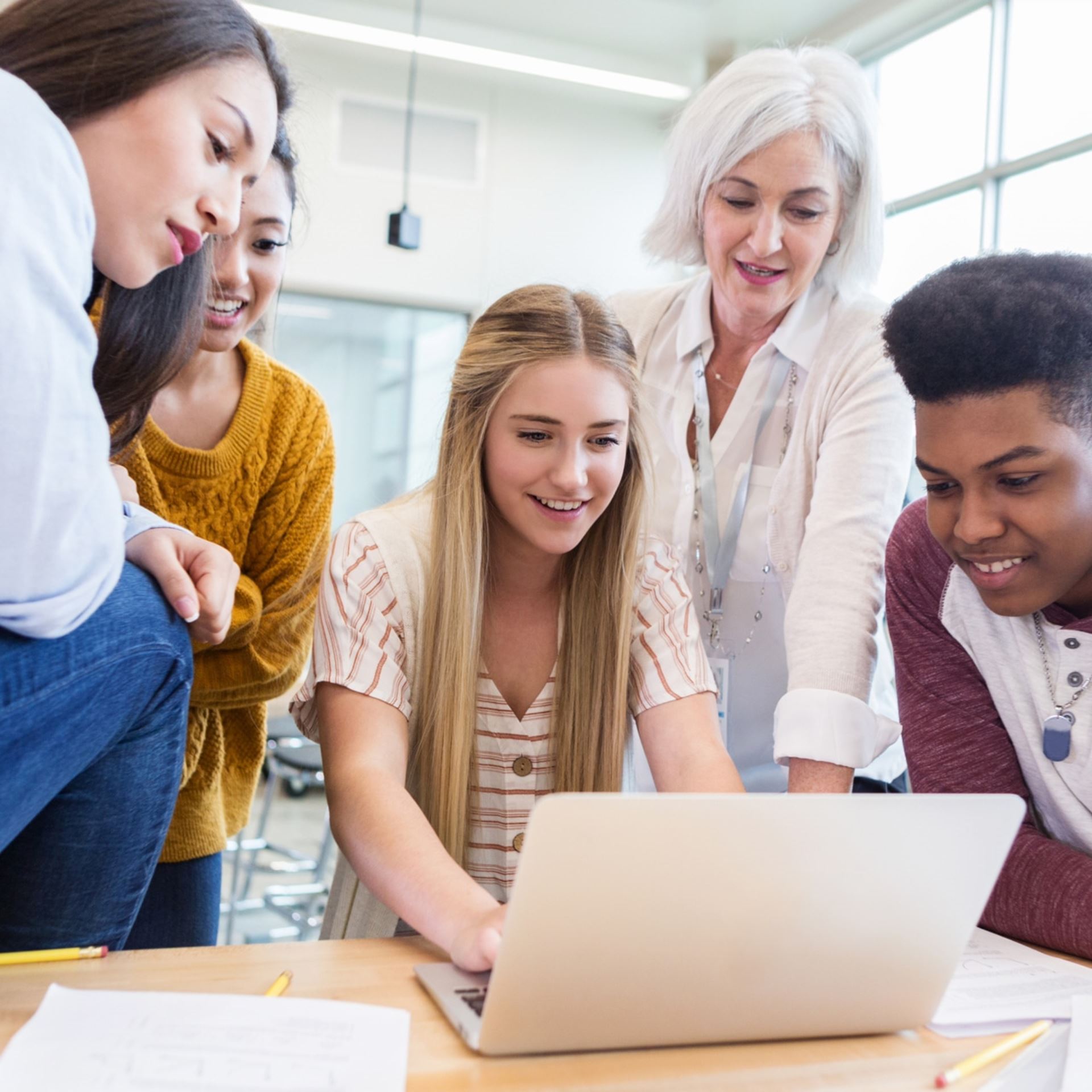 Groupe d'adolescents regarde un ordinateur en classe (Secondaire)