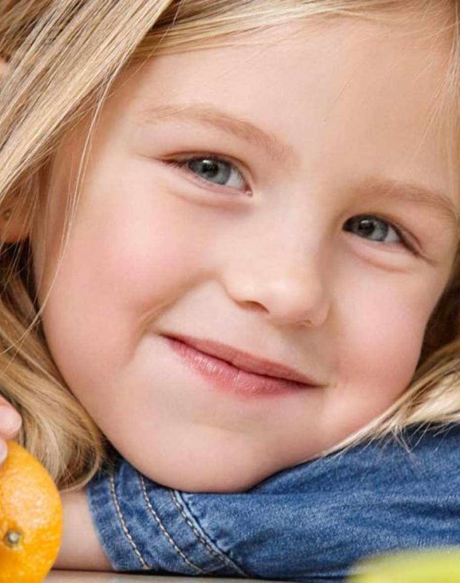 Young girl holding a clementine